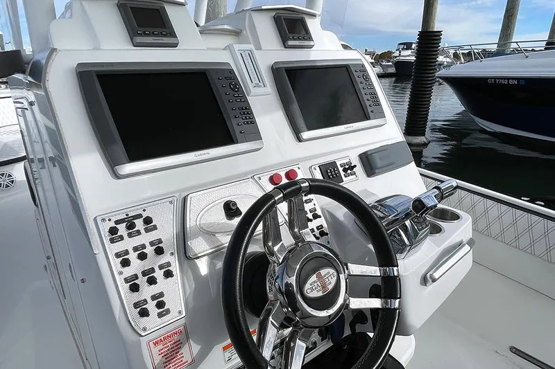 Slide: The Image of 2013 Cigarette 39 Top Gun Open boat dashboard with steering wheel and navigation screens. - 9