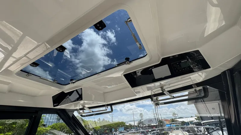 Slide: The Image of The image shows the roof of a Boston Whaler 365 Conquest with a large glass sunroof and blue sky. - 43