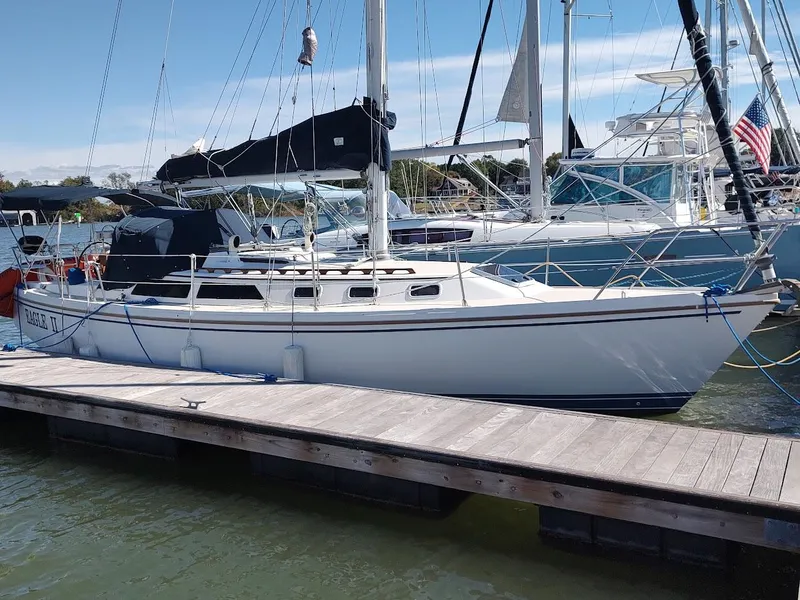 The Image of 1990 Catalina C-34 sailboat docked at marina, clear sky, calm water. - 0