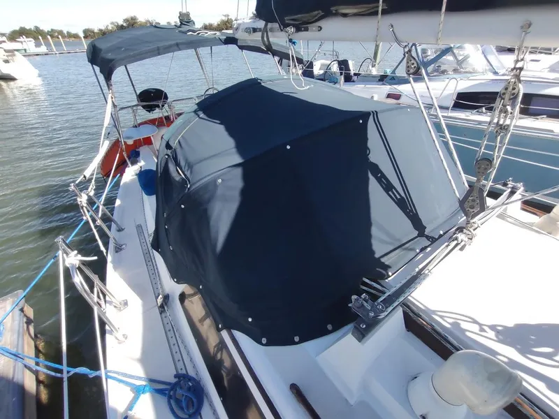 Slide: The Image of 1990 Catalina C-34 sailboat docked with blue canvas cover. - 12