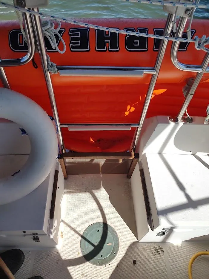 Slide: The Image of Sailboat deck with ladder, life preserver, and orange lifeboat on a 1990 Catalina C-34. - 23