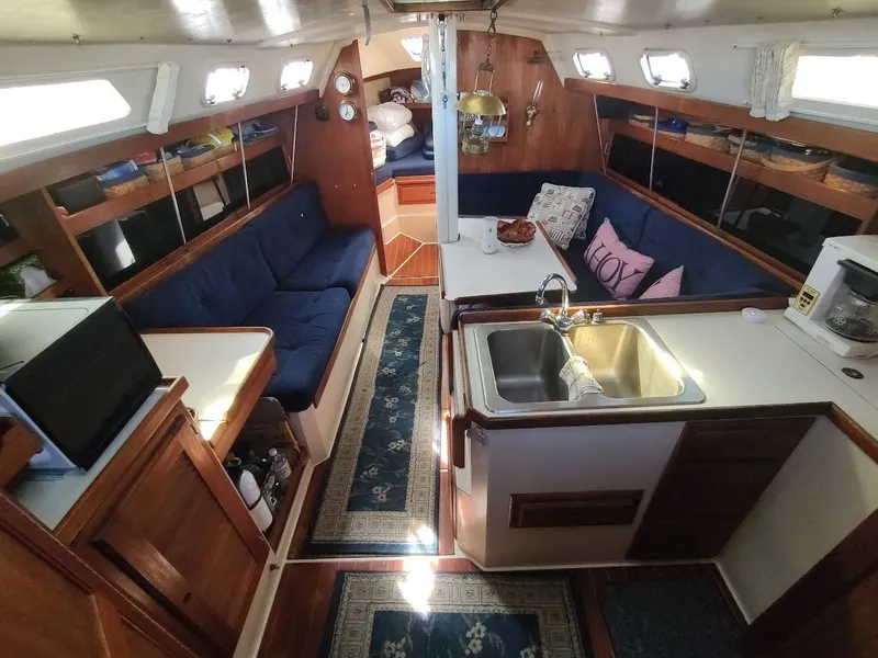 Slide: The Image of Interior of a 1990 Catalina C-34 sailboat with cozy seating and kitchen area. - 33
