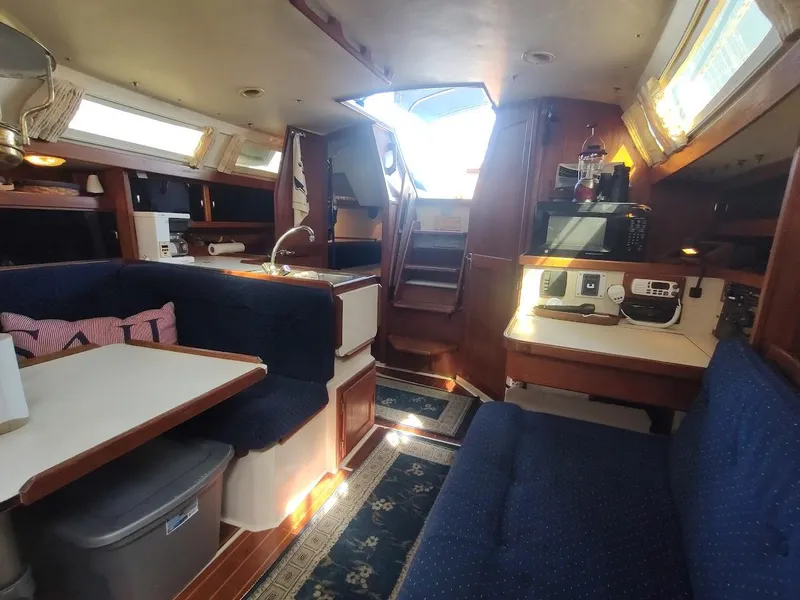 Slide: The Image of Interior of a 1990 Catalina C-34 sailboat with cozy seating and kitchen area. - 35
