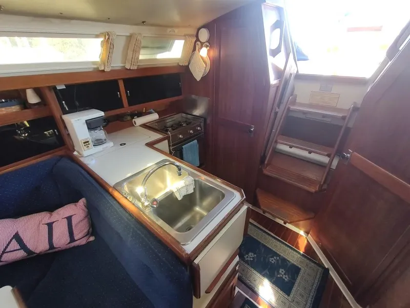Slide: The Image of Interior of 1990 Catalina C-34 sailboat with kitchen, sink, and wooden stairs. - 37