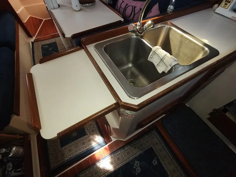 Slide: The Image of 1990 Catalina C-34 yacht kitchen with stainless steel sink and wooden countertops. - 45