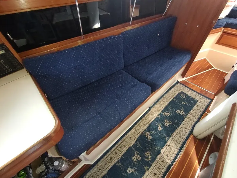 Slide: The Image of Interior of 1990 Catalina C-34 yacht with blue sofa and patterned rug. - 48