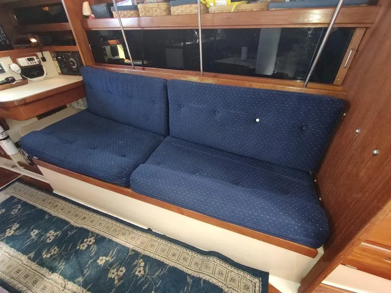 Slide: The Image of Blue cushioned seating in 1990 Catalina C-34 yacht interior with wooden accents. - 49