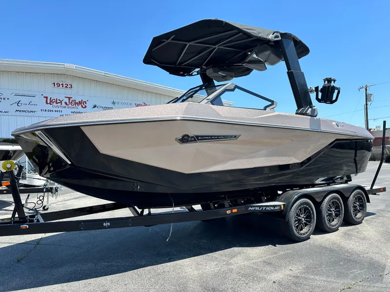 Slide: The Image of 2025 Nautique Super Air Nautique G23 boat on trailer, parked outdoors. - 2