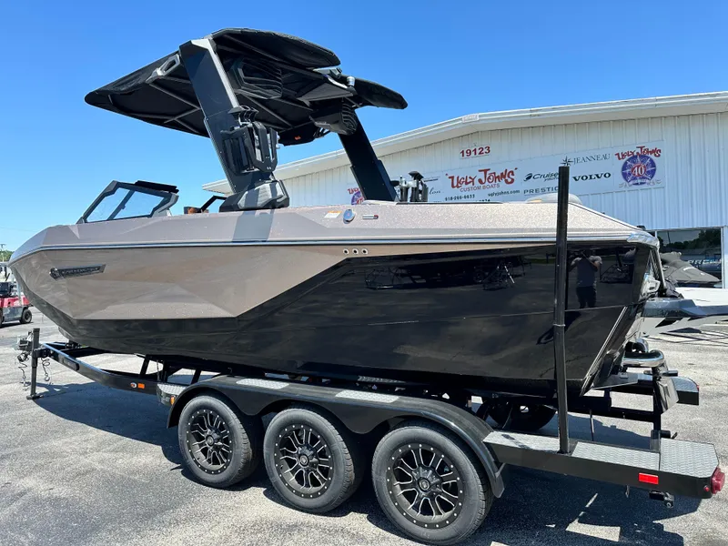 Slide: The Image of 2025 Nautique Super Air Nautique G23 boat on trailer, sleek design, black and gray finish. - 3