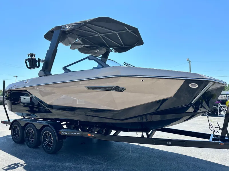 Slide: The Image of 2025 Nautique Super Air Nautique G23 boat on trailer under clear blue sky. - 5