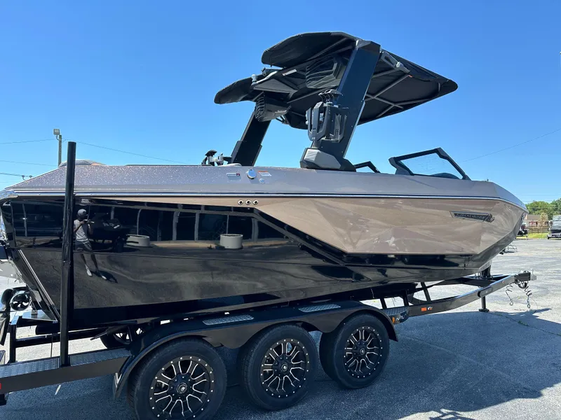 Slide: The Image of 2025 Nautique Super Air Nautique G23 boat on trailer, sleek design, black finish. - 6