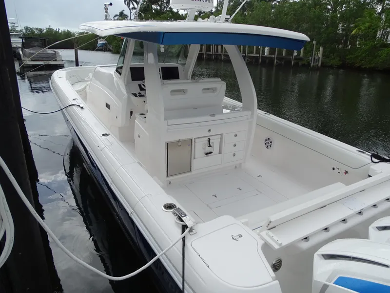 Slide: The Image of 2022 Intrepid 407 Panacea boat docked on calm water, featuring spacious deck and modern design. - 10