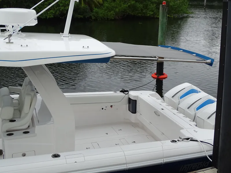 Slide: The Image of Intrepid 407 Panacea 2022 boat docked, featuring spacious deck and triple outboard engines. - 14