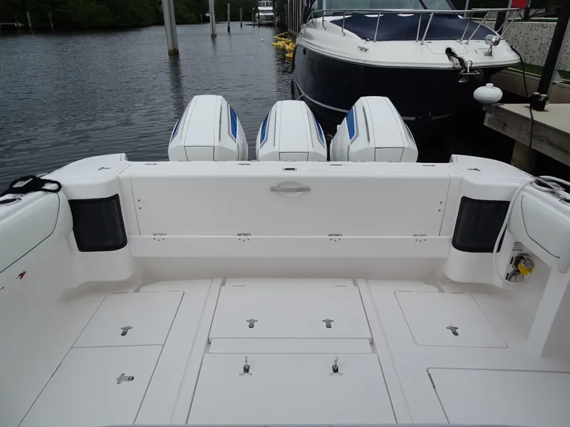 Slide: The Image of 2022 Intrepid 407 Panacea boat with triple outboard engines docked by the water. - 16