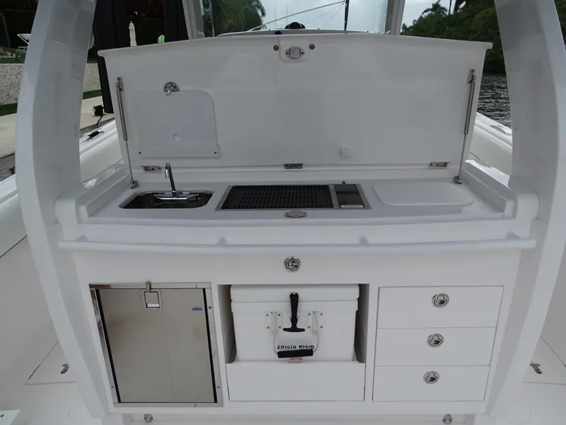 Slide: The Image of 2022 Intrepid 407 Panacea boat kitchen with sink, storage, and cooler. - 21