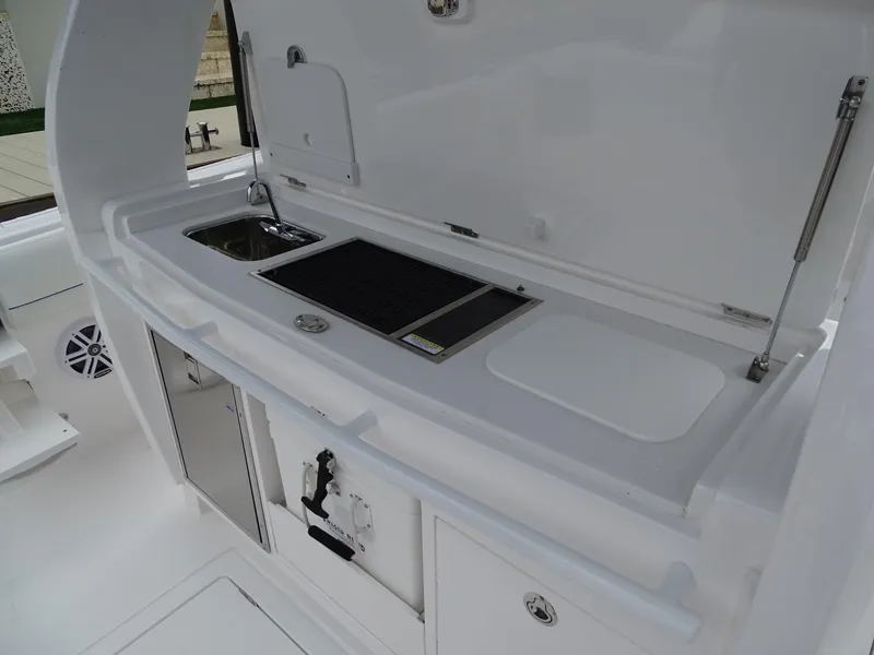 Slide: The Image of 2022 Intrepid 407 Panacea boat kitchen area with sink and storage compartments. - 22