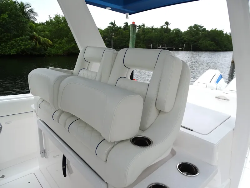 Slide: The Image of Luxurious seating on 2022 Intrepid 407 Panacea boat, featuring white upholstery and cup holders. - 25
