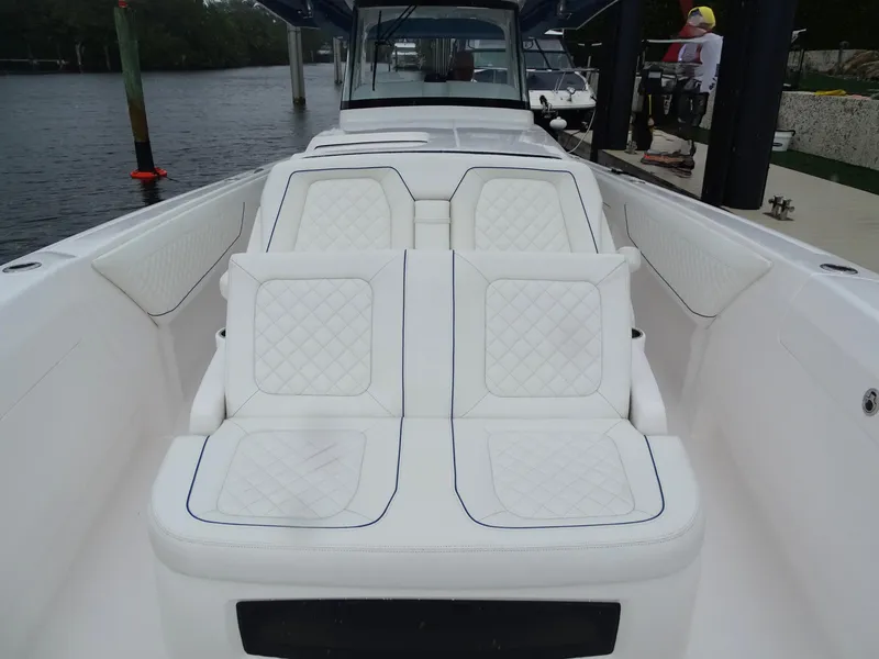 Slide: The Image of 2022 Intrepid 407 Panacea boat with luxurious white seating, docked by the water. - 37