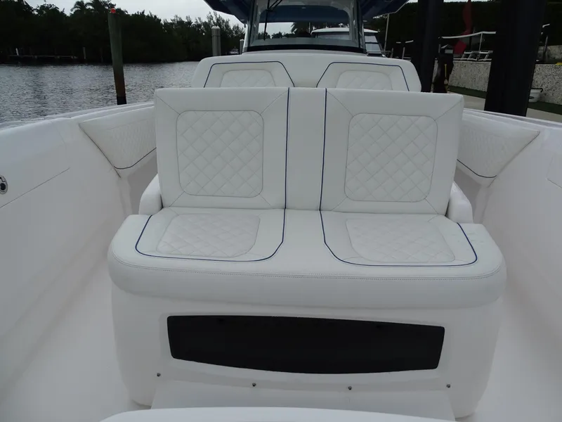 Slide: The Image of 2022 Intrepid 407 Panacea boat with white cushioned seating, docked by the water. - 39