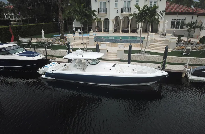 Slide: The Image of 2022 Intrepid 407 Panacea boat docked near luxury waterfront home. - 4