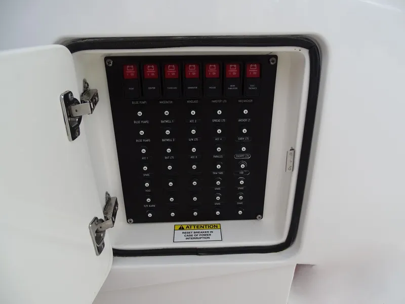 Slide: The Image of Control panel of 2022 Intrepid 407 Panacea boat with labeled switches and warning sign. - 47