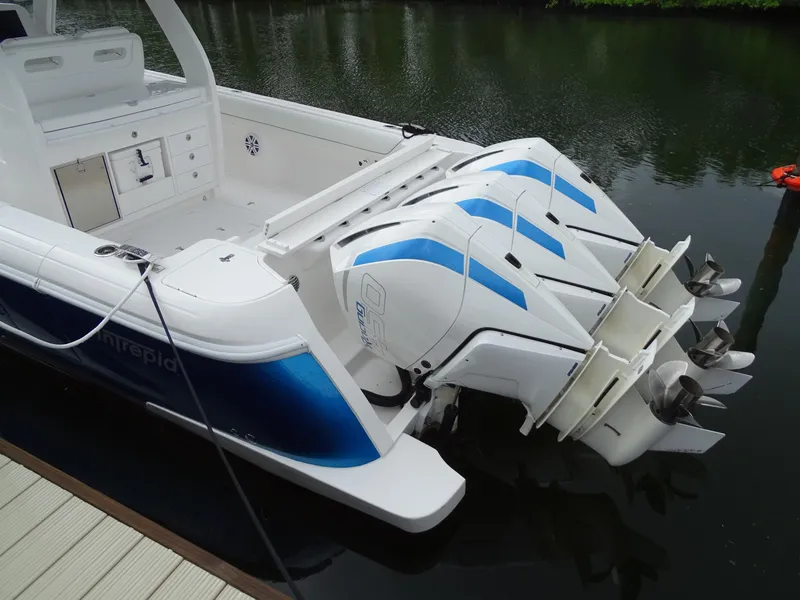 Slide: The Image of 2022 Intrepid 407 Panacea boat with triple outboard engines docked on calm water. - 8