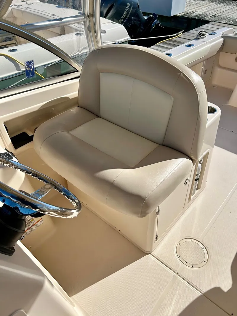 Slide: The Image of 2012 Grady-White Freedom 285 boat interior with beige seating and steering wheel. - 10