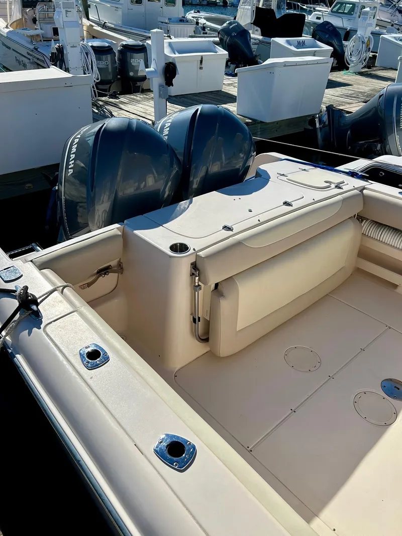 Slide: The Image of 2012 Grady-White Freedom 285 boat with dual outboard motors at a marina. - 17