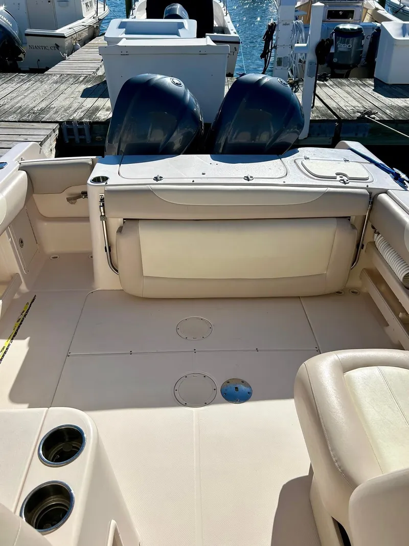 Slide: The Image of 2012 Grady-White Freedom 285 boat interior with dual engines at dock. - 20