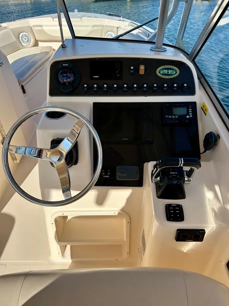 Slide: The Image of 2012 Grady-White Freedom 285 boat dashboard with steering wheel and controls. - 9