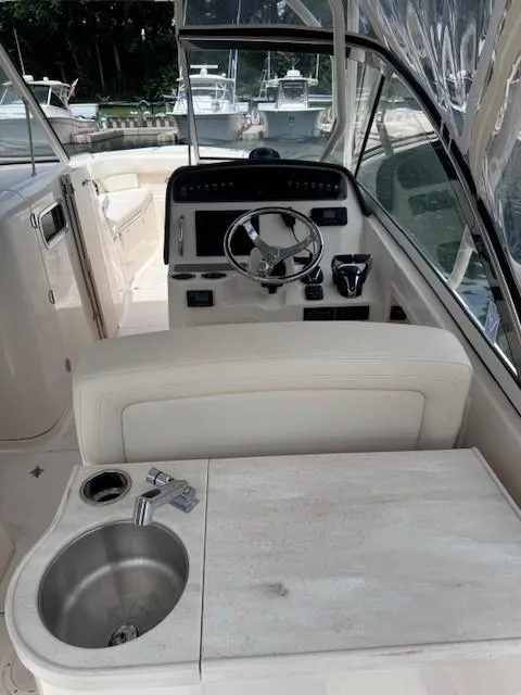 Slide: The Image of 2023 Grady-White Freedom 307 boat interior with steering wheel and sink. - 11
