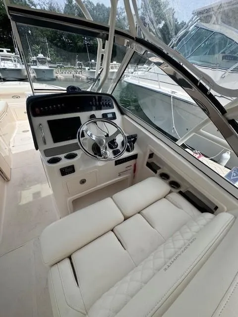 Slide: The Image of 2023 Grady-White Freedom 307 boat interior with steering wheel and seating. - 8