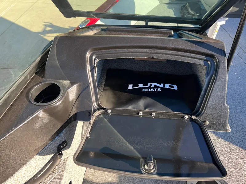 Slide: The Image of 2025 Lund 1775 Adventure Sport boat dashboard with open storage compartment. - 16