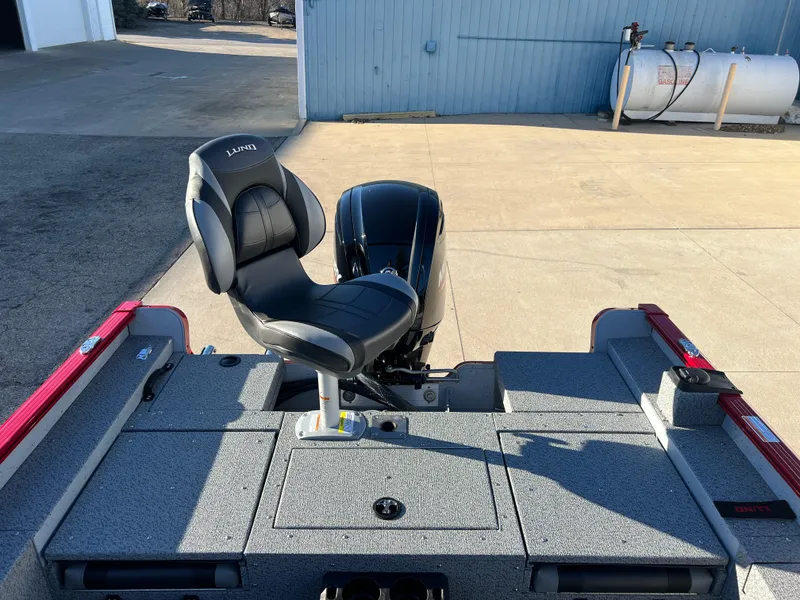 Slide: The Image of 2025 Lund 1775 Adventure Sport boat with a sleek seat and motor, parked outdoors. - 21