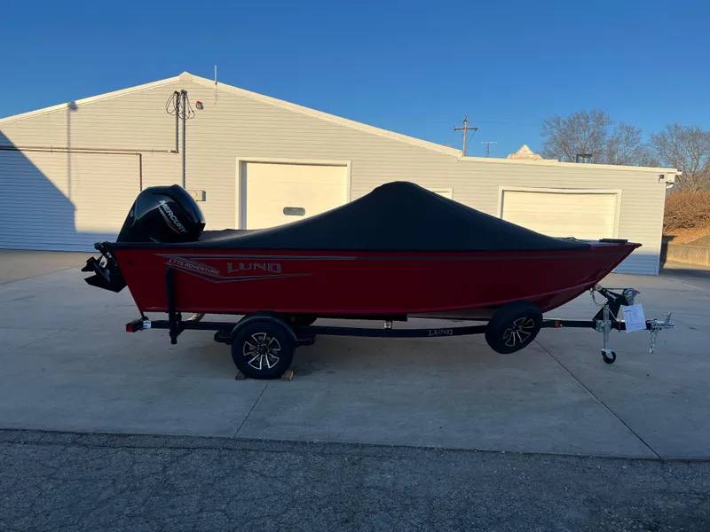 Slide: The Image of 2025 Lund 1775 Adventure Sport boat with cover on trailer, parked outdoors. - 23