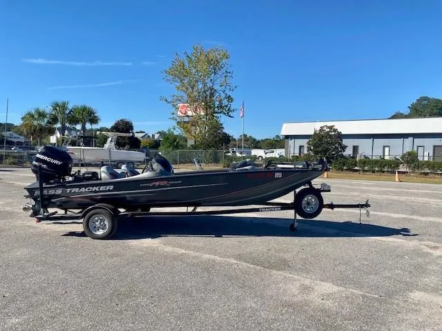 The Image of 2014 Bass Tracker PRO TEAM 190 boat on trailer in parking lot. - 0