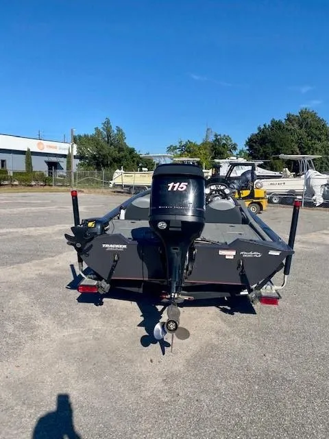 Slide: The Image of 2014 Bass Tracker PRO TEAM 190 boat with 115 HP motor in a parking lot. - 2