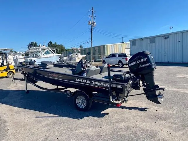 Slide: The Image of 2014 Bass Tracker PRO TEAM 190 boat with Mercury outboard motor in a parking lot. - 3