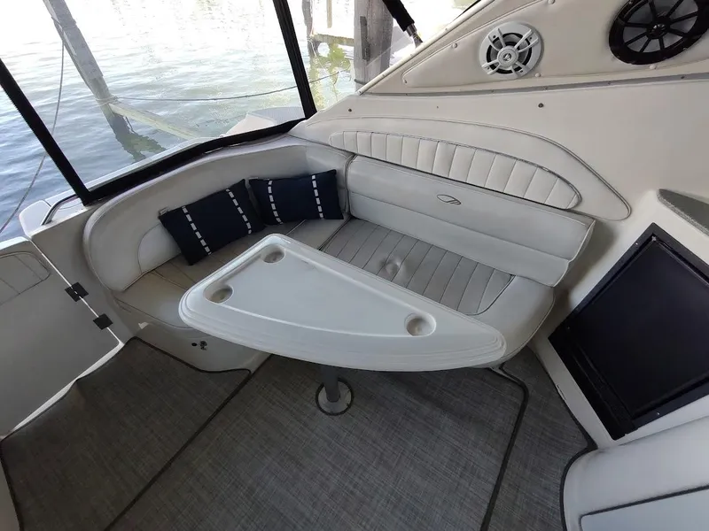 Slide: The Image of 1999 Maxum 4100 SCR boat interior with cushioned seating and table. - 10