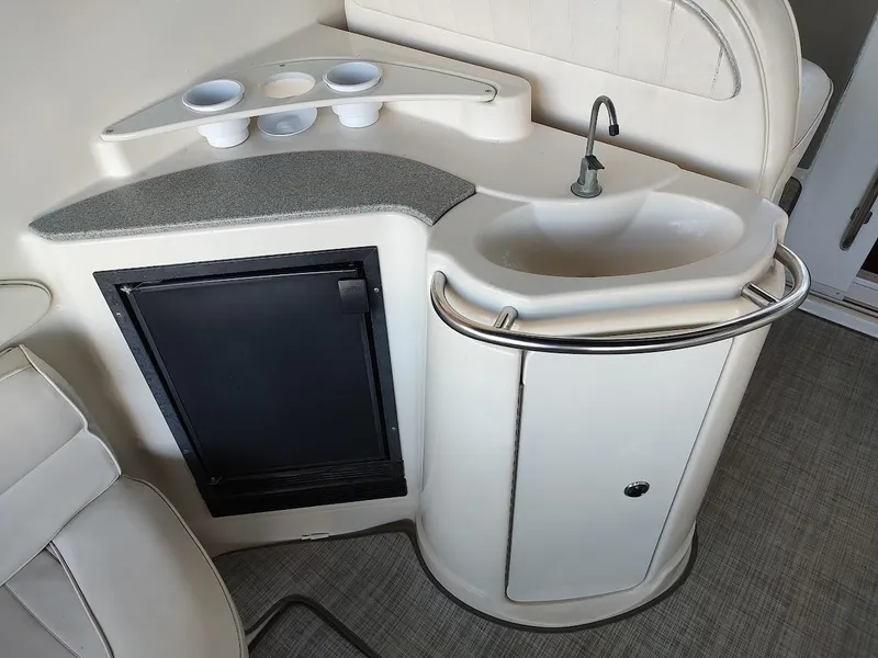 Slide: The Image of 1999 Maxum 4100 SCR yacht kitchenette with sink, mini fridge, and cup holders. - 19