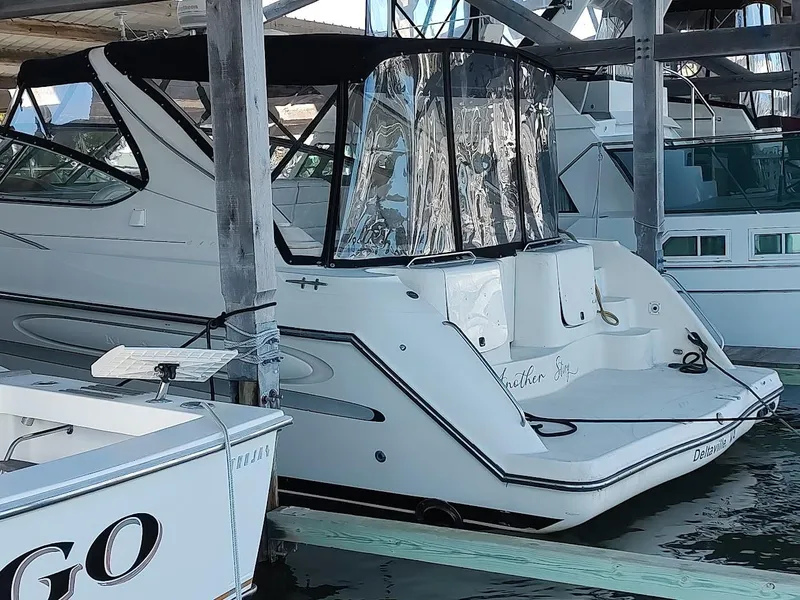 Slide: The Image of 1999 Maxum 4100 SCR yacht docked in a marina, featuring sleek design and covered cockpit. - 2