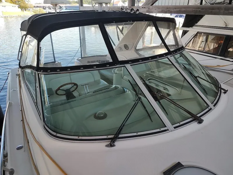 Slide: The Image of 1999 Maxum 4100 SCR boat with covered cockpit, docked by the water. - 24