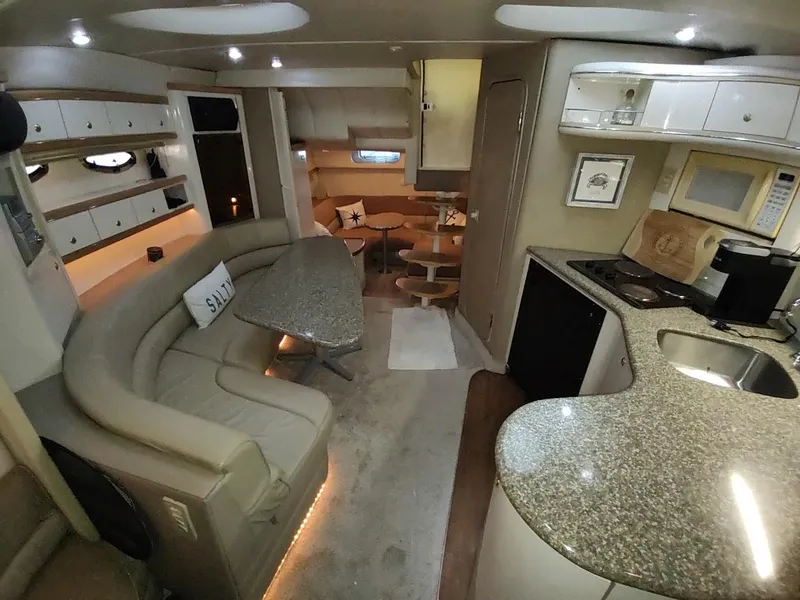 Slide: The Image of 1999 Maxum 4100 SCR yacht interior with modern kitchen, cozy seating, and elegant dining area. - 27