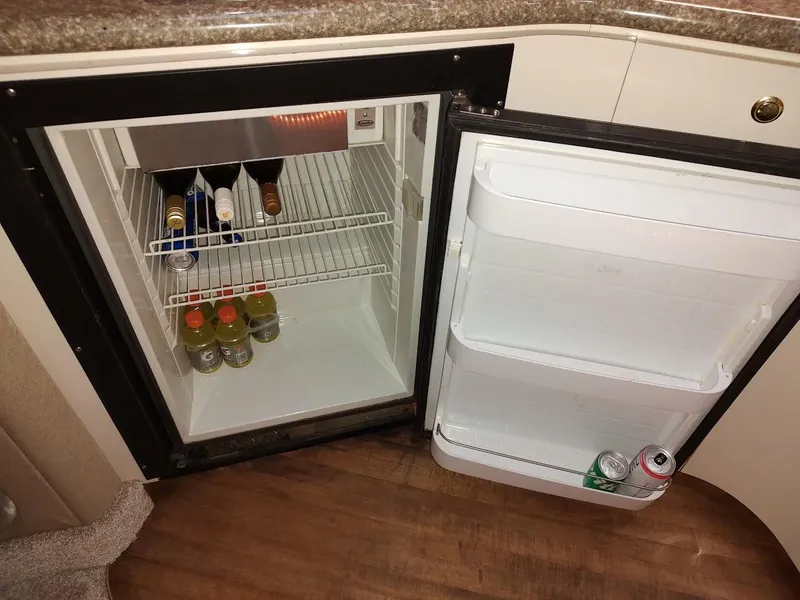 Slide: The Image of Mini fridge stocked with drinks inside a 1999 Maxum 4100 SCR boat. - 33