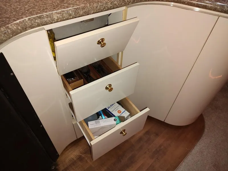 Slide: The Image of Open drawers in a 1999 Maxum 4100 SCR yacht kitchen, showing utensils and items. - 34