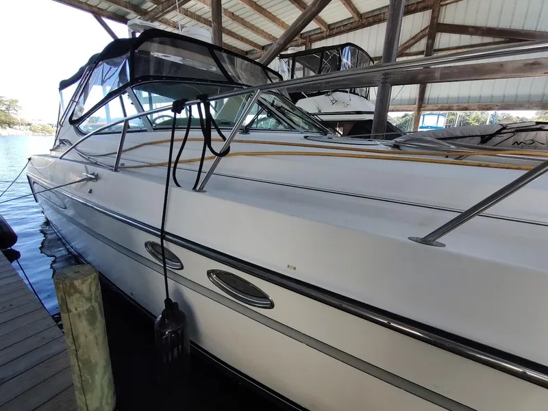 Slide: The Image of 1999 Maxum 4100 SCR yacht docked under a covered marina. - 4