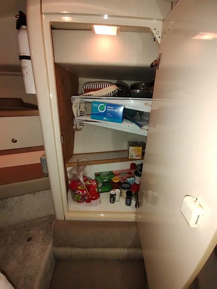 Slide: The Image of Cabinet interior on 1999 Maxum 4100 SCR boat, stocked with kitchen supplies and food items. - 40
