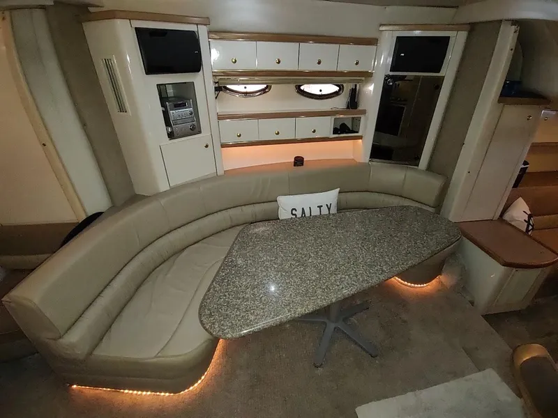 Slide: The Image of 1999 Maxum 4100 SCR yacht interior with curved seating, granite table, and ambient lighting. - 42