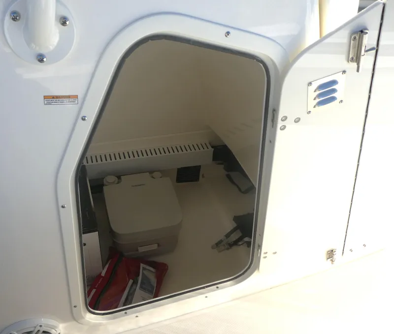 Slide: The Image of Storage compartment on 2025 Boston Whaler 230 Outrage boat, featuring a portable toilet. - 13