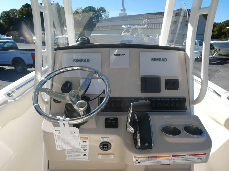 Slide: The Image of 2025 Boston Whaler 230 Outrage boat console with steering wheel and Simrad electronics. - 5